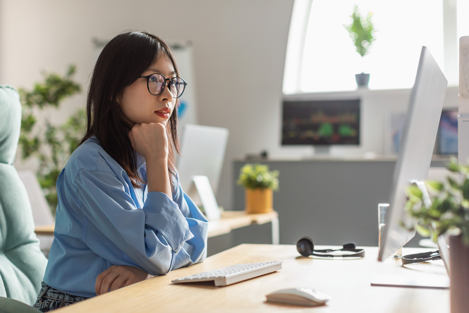 Woman looking at a monitor at a desk.