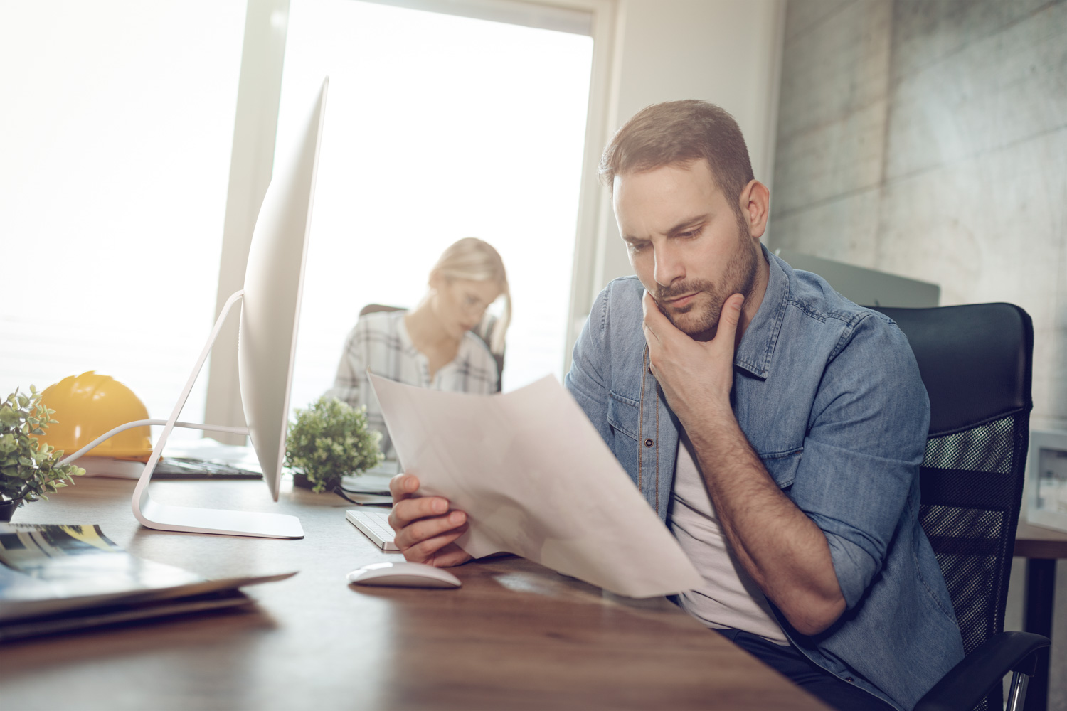 Man looking at notes at a desk.