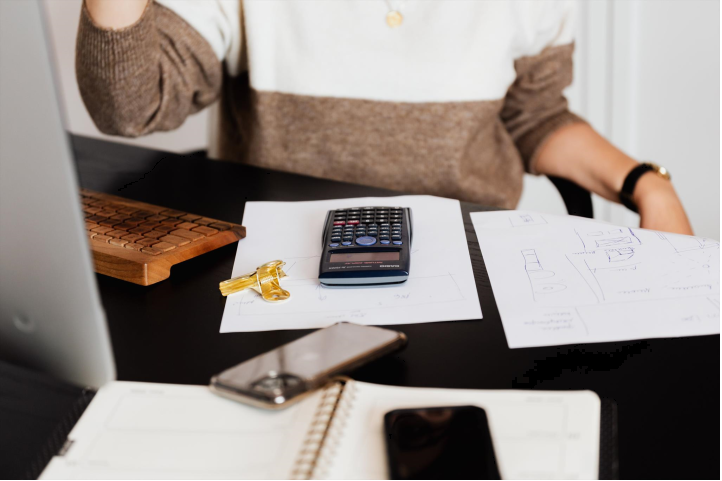 Woman at desk with a calculator.